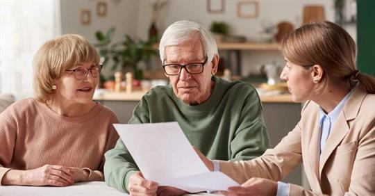 An older man and woman reviewing estate planning documents with an attorney