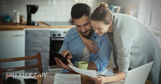 Young couple smiling while looking at finances together