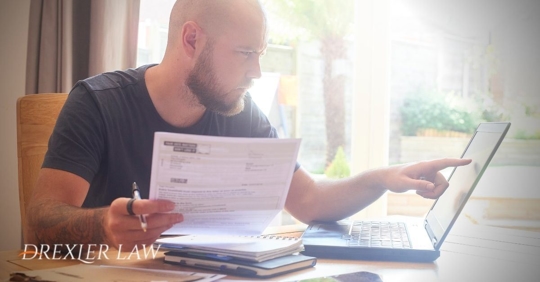 Image of a man at his computer going over his finances