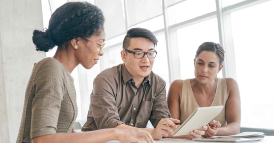 A man and woman reviewing a document with a female attorney