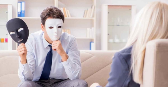 A man holding up various masks to his face while speaking with a woman