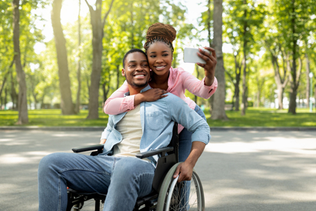 man in wheelchair taking a selfie with partner