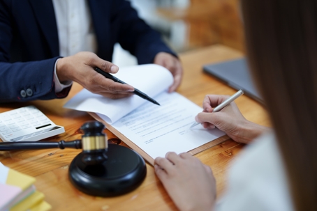 person signing documents at lawyer's office