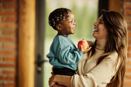 Happy mother enjoying with her adopted son at home.