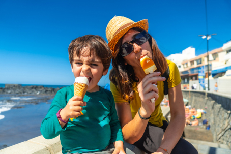 mother and son eating ice cream by the sea